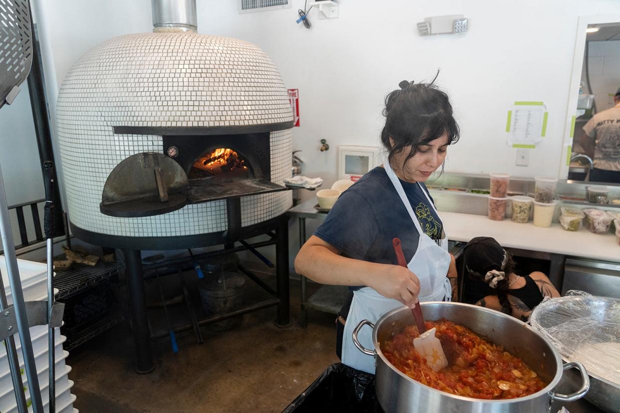 Employee Gaby Rodriguez prepares food ahead of dinner at Bufalina. As Austin experiences extreme heat, the restaurant has had to install additional equipment to keep the building cool.