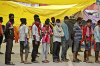 People wearing face masks line up to consult doctors at a COVID-19 screening facility inside a government hospital in Jammu, India, Tuesday, July 21, 2020. With a surge in coronavirus cases in the past few weeks, state governments in India have been ordering focused lockdowns in high-risk areas to slow down the spread of infections.(AP Photo/Channi Anand)