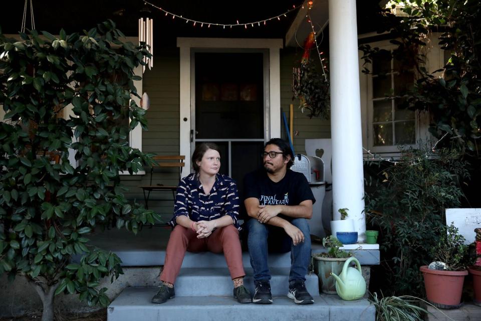 A woman and man sit on a front porch