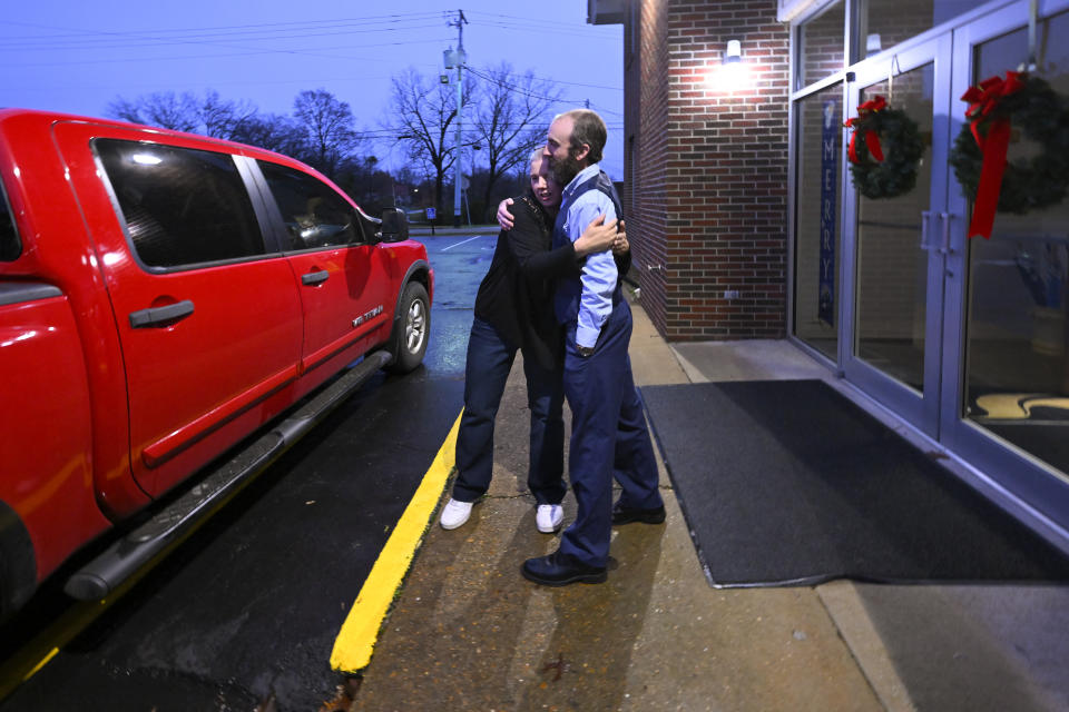 Laura Lamb, left, hugs Pastor Adam Kelchner after helping her husband, Jerry, who suffers from a spine condition, into their truck while leaving Camden First United Methodist Church Thursday, Dec. 8, 2022, in Camden, Tenn. The church at the urging of the pastor recently had a couple pews cut in half so Jerry, and anyone else who uses a wheelchair, walker or other aid, can still sit with the rest of the congregation. (AP Photo/John Amis)