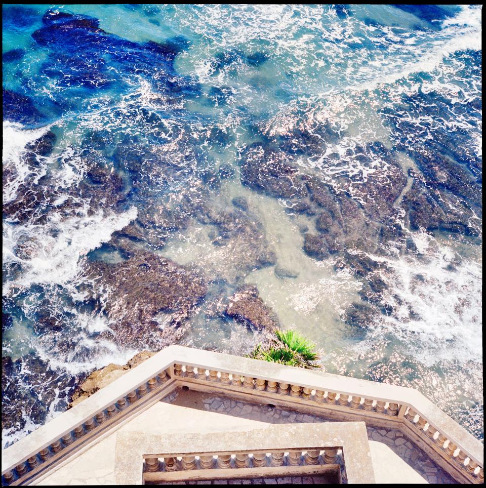 Directly below Valentino creative director Pierpaolo Piccioli’s seaside getaway in Nettuno, his hometown on the Tyrrhenian coast, the crystalline waters crash up against a classical column balustrade and a low terrazzo deck, photographed by Piccioli's friend and collaborator Lorenzo Castore. It played a supporting role in Piccioli’s latest Valentino resort 2021 look book, where the designer himself photographed Italian supermodel Mariacarla Boscono in his designs.