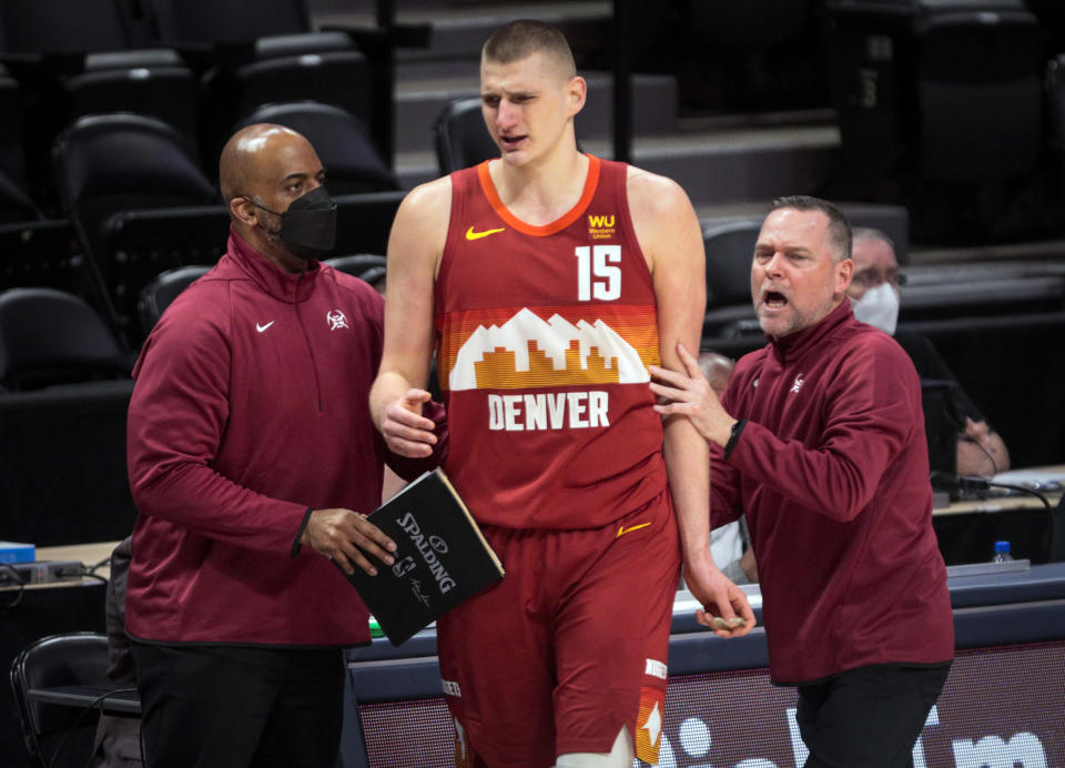 Denver Nuggets center Nikola Jokic (15) is led to the bench by Nuggets coach Michael Malone, right, and an unidentified assistant after Jokic was called for a technical foul against the Portland Trail Blazers in the third quarter of Game 2 of a first-round NBA basketball playoff series Monday, May 24, 2021, in Denver. (AP Photo/Joe Mahoney)