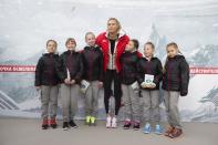 Russian tennis player Maria Sharapova poses with children while visiting her first court of Kafelnikov Tennis School in Riviera Park in Sochi, Russia, Wednesday, Feb. 5, 2014, prior to the start of the 2014 Winter Olympics. (AP Photo/Pavel Golovkin)