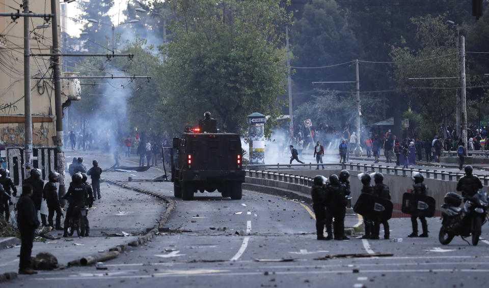 A police armored vehicle drives toward a group of protesters, in Quito, Ecuador, Friday, Oct. 4, 2019, during a nationwide transport strike that shut down taxi, bus and other services in response to a sudden rise in fuel prices. Ecuador's President Lenín Moreno, who earlier declared a state of emergency over the strike, vowed Friday that he wouldn't back down on the decision to end costly fuel subsidies, which doubled the price of diesel overnight and sharply raised gasoline prices. (AP Photo/Dolores Ochoa)