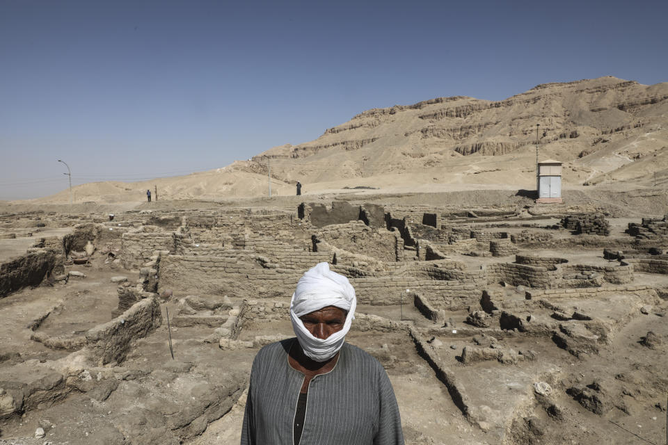 Worker stands in a 3,000-year-old lost city in Luxor province, Egypt, Saturday, April 10, 2021. The newly unearthed city is located between the temple of King Rameses III and the colossi of Amenhotep III on the west bank of the Nile in Luxor. The city continued to be used by Amenhotep III's grandson Tutankhamun, and then his successor King Ay. (AP Photo/Mohamed Elshahed)