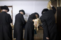 Ultra-Orthodox Jews swing chickens over their heads during the Kaparot ritual, in Bnei Brak, Israel, Sunday, Sept 27, 2020. Observant Jews believe the ritual transfers one's sins from the past year into the chicken, and is performed before the Day of Atonement, Yom Kippur, the holiest day in the Jewish year which starts at sundown Sunday. The solemn Jewish holiday of Yom Kippur, which annually sees Israeli life grind to a halt, arrived on Sunday in a nation already under a sweeping coronavirus lockdown. (AP Photo/Oded Balilty)
