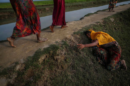 An exhausted Rohingya refugee fleeing violence in Myanmar cries for help from others crossing into Palang Khali, near Cox's Bazar, Bangladesh November 2, 2017. REUTERS/Hannah McKay