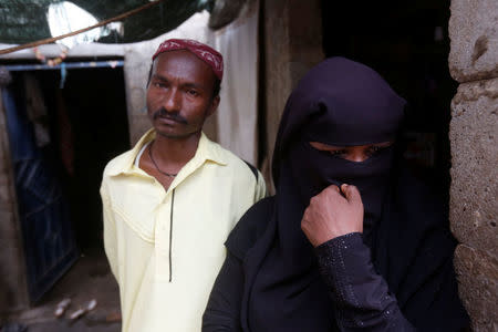 Raheela Sadiq (R), a Rohingya immigrant living in Pakistan, reacts while standing with her husband Mohammad Sadiq during an interview with Reuters at her residence in Arkanabad neighborhood in Karachi, Pakistan September 7, 2017. Picture taken September 7, 2017. REUTERS/Akhtar Soomro