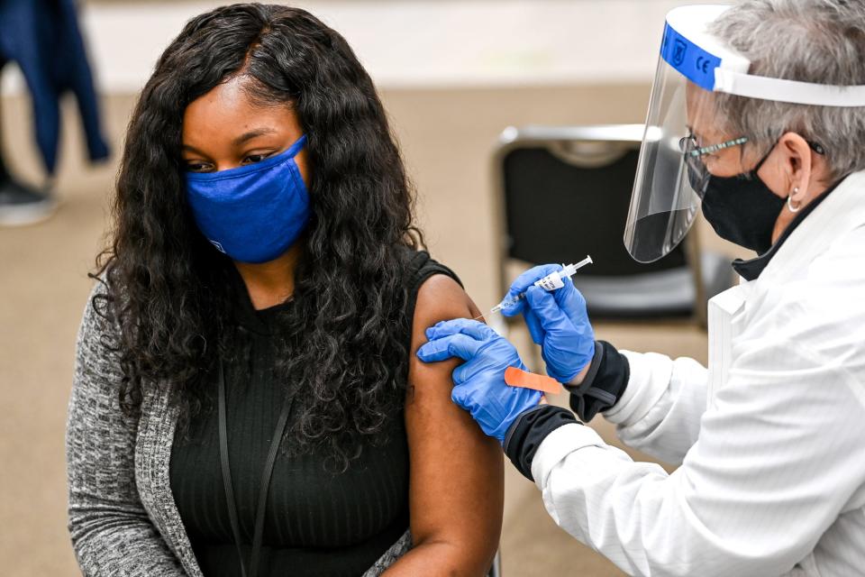 Constance Botke gives Micah Pierce of Lansing, Mich., her first COVID-19 vaccination shot on April 12 at Sparrow's COVID-19 vaccination site in Lansing.