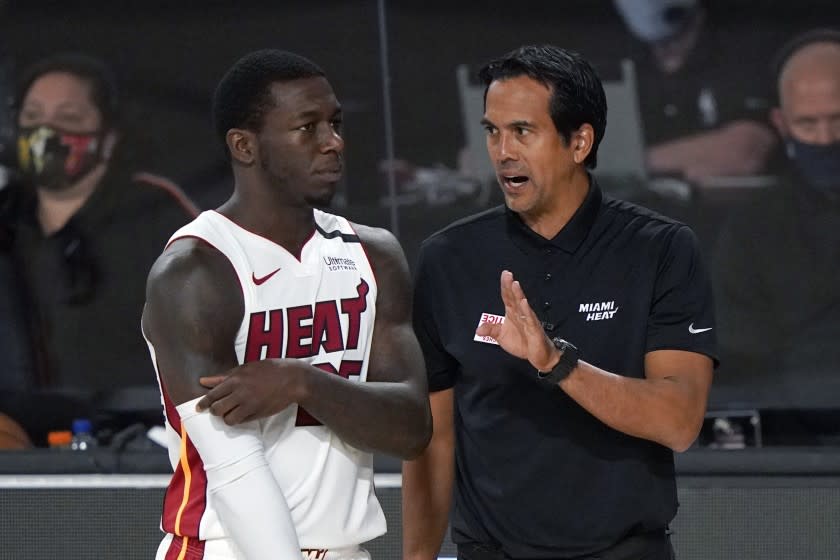Miami Heat head coach Erik Spoelstra, right, talks with Kendrick Nunn, left, during the first half an NBA conference semifinal playoff basketball game against the Milwaukee Bucks, Wednesday, Sept. 2, 2020, in Lake Buena Vista, Fla. (AP Photo/Mark J. Terrill)