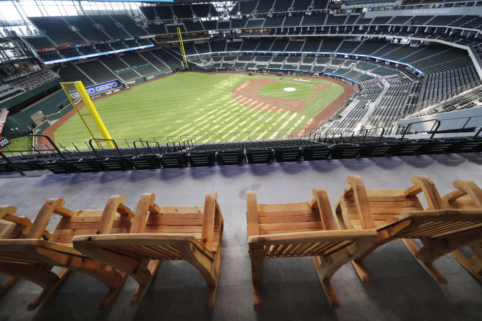 FILE - In this Thursday, July 23, 2020, file photo, oversized rocking chairs sit ready for fans on the patio at the Texas Rangers home baseball stadium, Globe Life Field, in Arlington, Texas. The Texas Rangers could have a full house for their home opener next month after debuting their new 40,518-seat stadium without fans in the stands for their games last season. If that happens, the Rangers could be the first team in MLB or any U.S.-based sport to have a full-capacity crowd since the coronavirus pandemic started rapidly shutting down sports a year ago this week. (AP Photo/LM Otero, File)