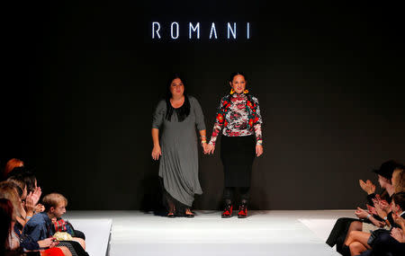 Designers Erika(L) and Helena Varga walk on the catwalk at a fashion show of Romani Design in Budapest, Hungary, November 12, 2016. REUTERS/Laszlo Balogh