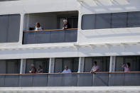 Passengers look out from Carnaval's Holland America cruise ship Rotterdam as it arrives at Port Everglades during the new coronavirus pandemic, Thursday, April 2, 2020, in Fort Lauderdale, Fla. Those passengers that are fit for travel in accordance with guidelines from the U.S. Centers for Disease Control will be permitted to disembark. (AP Photo/Lynne Sladky)