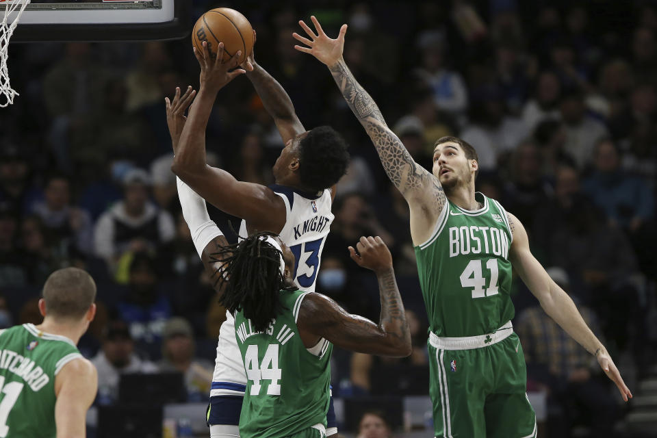 Minnesota Timberwolves forward Nathan Knight (13) goes up to the basket against Boston Celtics forwards Justin Jackson (44) and Juancho Hernangomez (41) during the first half of an NBA basketball game Monday, Dec. 27, 2021, in Minneapolis. (AP Photo/Stacy Bengs)