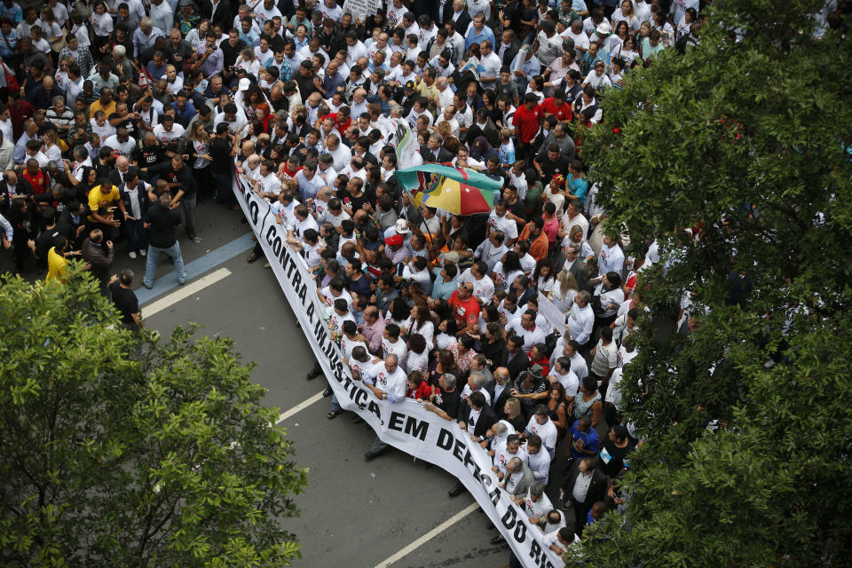 People protest with a banner that reads in Portuguese "Against injustice, in defense of Rio" in Rio de Janeiro, Brazil, Monday, Nov. 26, 2012. Thousands of demonstrators are gathering in downtown Rio de Janeiro for a march against legislation that officials here insist would strip this oil-producing state of much of its income from the energy sector. (AP Photo/Victor R. Caivano)