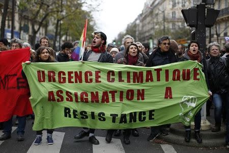 Environmentalists walk behind a banner which reads, "Climate Emergency. Summon to Resistance" near the Place de la Republique after the cancellation of a planned climate march following shootings in the French capital, ahead of the World Climate Change Conference 2015 (COP21), in Paris, France, November 29, 2015. REUTERS/Benoit Tessier