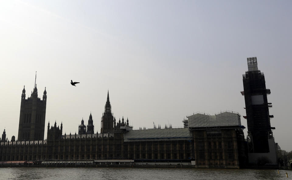 FILE - Britain's Houses of Parliament, covered in hoarding and scaffolding as it undergoes restoration work to repair the crumbling building, in London, Wednesday, April 17, 2019. British lawmakers are warning that the country's Parliament building is at “real and rising” risk of destruction. The House of Commons Public Accounts Committee said Parliament is “leaking, dropping masonry and at constant risk of fire,” as well as riddled with asbestos. The committee said Wednesday, May 17, 2023 that “there is a real and rising risk that a catastrophic event will destroy” the building before long-delayed restoration work is done. (AP Photo/Kirsty Wigglesworth, File)
