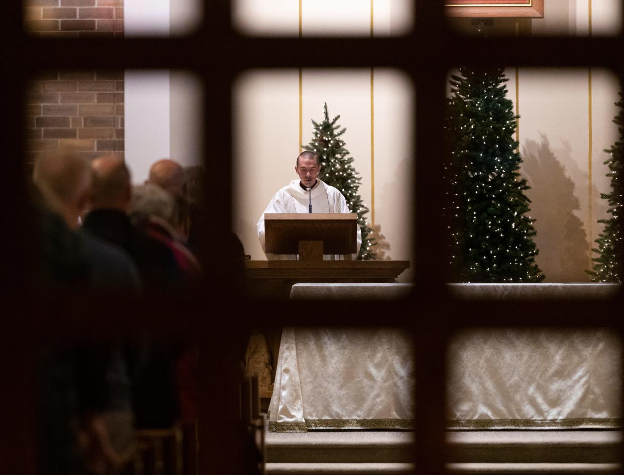 Father Matthew Widder reads the Gospel during Christmas Eve mass Friday at St. William Catholic Church in Waukesha, Wis. St. William is one of four parishes that make up the “Catholic Community of Waukesha”. Several of their members were struck and seriously injured Nov. 21, when a man driving a red Ford Escape plowed into the city's annual Christmas parade, leaving six dead and more than 60 injured.