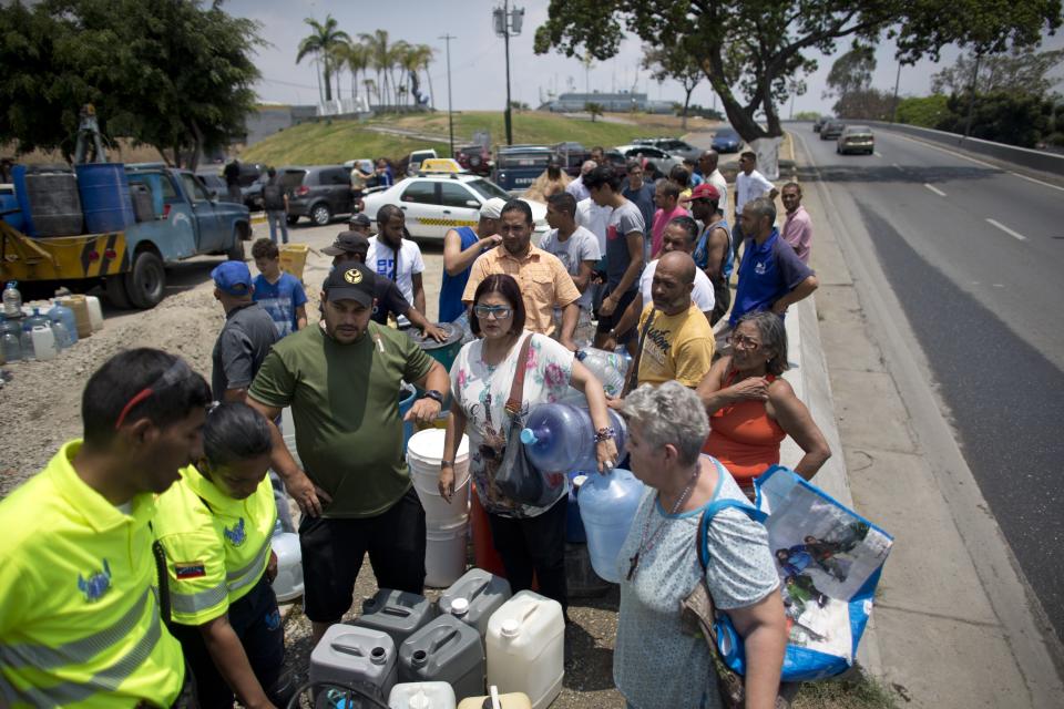 Residents wait in line to fill their containers with water, in Caracas, Venezuela, Monday, April 1, 2019. Since a massive power failure struck March 7, the nation has experienced near-daily blackouts and a breakdown in critical services such as running water and public transportation. (AP Photo/Ariana Cubillos)