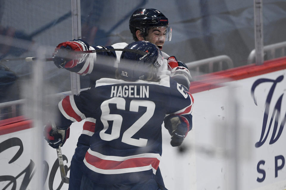 Washington Capitals defenseman Justin Schultz, back, celebrates his goal with left wing Carl Hagelin (62) during the third period of the team'[s NHL hockey game against the New York Islanders, Tuesday, Jan. 26, 2021, in Washington. (AP Photo/Nick Wass)