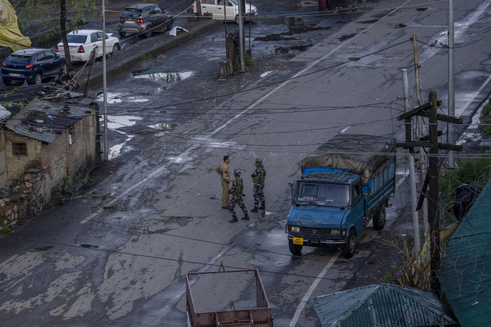 Security forces stands guard near a barbed wire set up to divert traffic for a Muharram procession in Srinagar, Indian controlled Kashmir, Thursday, July 27, 2023. Muharram is a month of mourning for Shiite Muslims in remembrance of the martyrdom of Imam Hussein, the grandson of the Prophet Muhammad. (AP Photo/Dar Yasin)