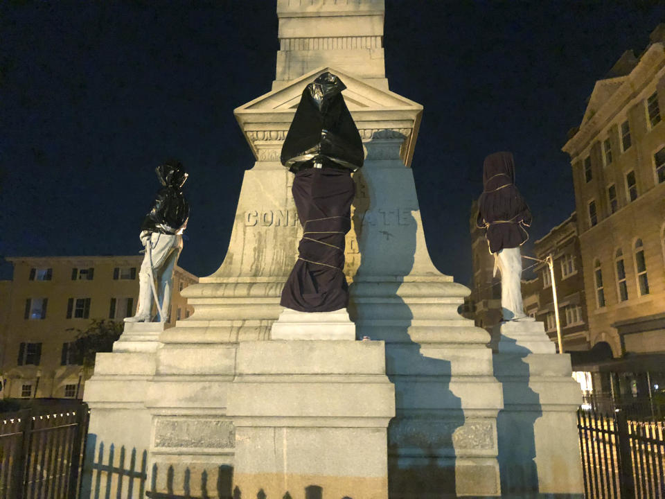 The Confederate monument is covered in sheets and bags in Downtown Portsmouth, Va., early Wednesday, June 10, 2020. Protesters covered the monument with trash bags and sheets Wednesday, several hours after the city's council members had a meeting to figure out ways to relocate it. (Kiahnna Patterson/WAVY-TV 10 via AP)