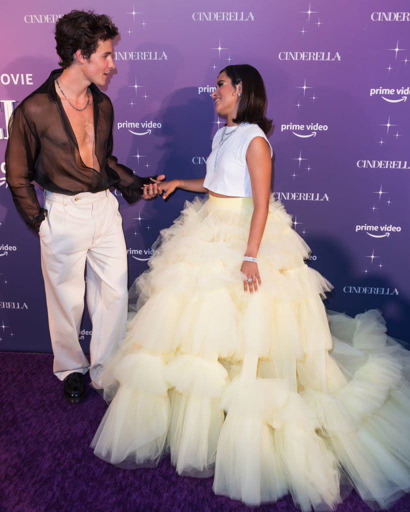 Shawn and Camila hold hands and look at each other on the red carpet