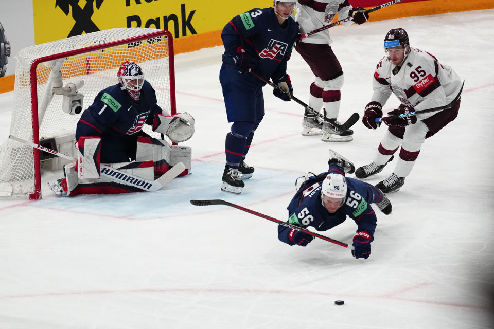 United States Rocco Grimaldi (56) falls to the ice defending the net against Latvia's Oskars Batna (95) in their bronze medal match at the Ice Hockey World Championship in Tampere, Finland, Sunday, May 28, 2023. (AP Photo/Pavel Golovkin)
