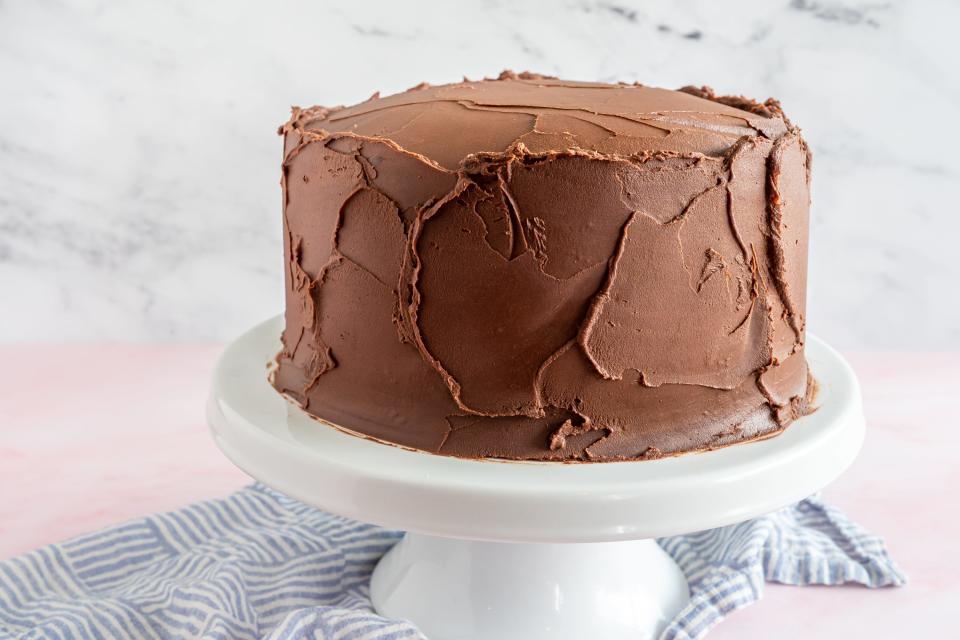 a round chocolate layer cake on a white cake stand