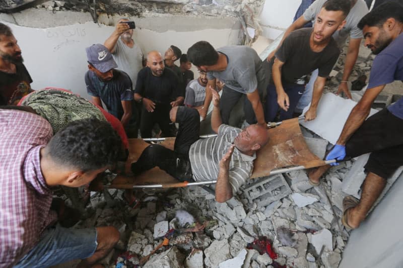 An injured Palestinian is transported from a school after it was hit by an Israeli strike, in Deir el-Balah in the central Gaza Strip. Omar Ashtawy/APA Images via ZUMA Press Wire/dpa