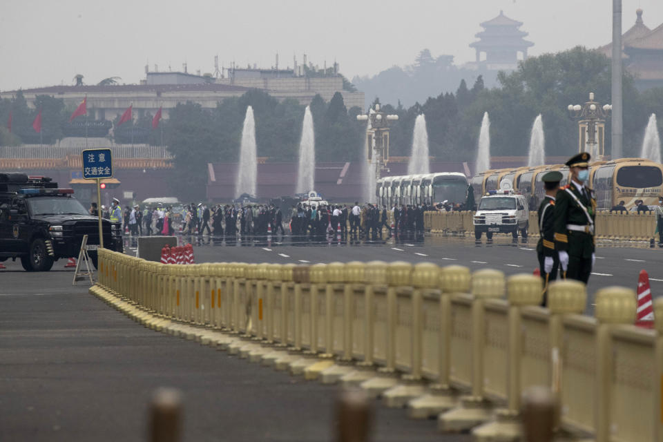Delegates attending the opening session of the Chinese People's Political Consultative Conference (CPPCC) cross the road to enter the Great Hall of the People in Beijing, Thursday, May 21, 2020. (AP Photo/Ng Han Guan)