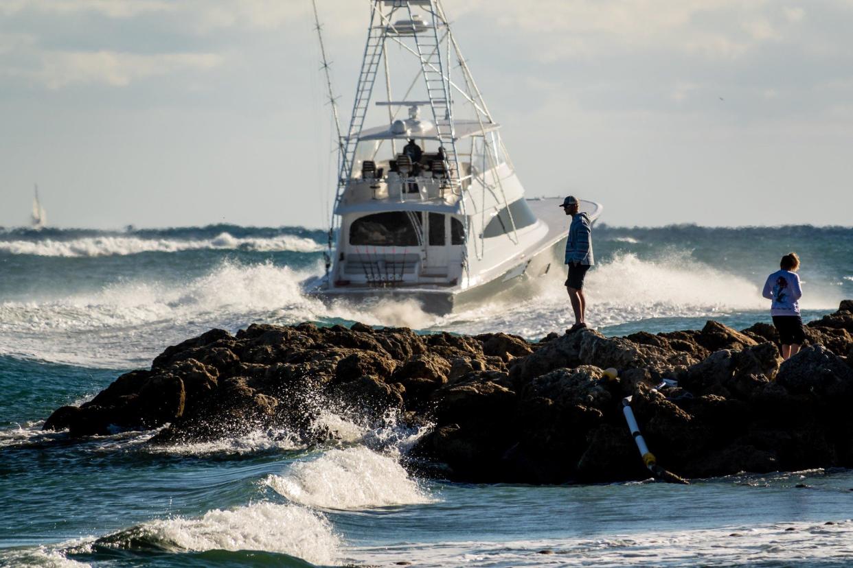 Visitors watch boats leave the Jupiter inlet on Tuesday December 3, 2019.