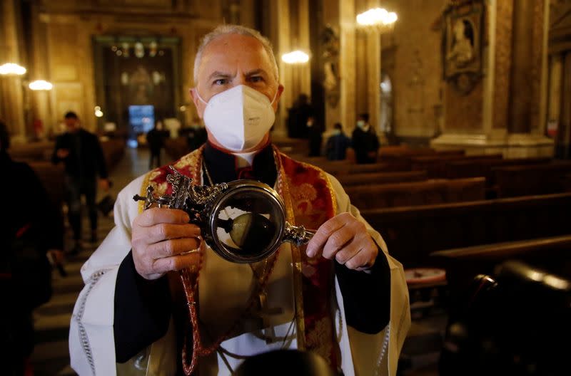 Foto del miércoles del abad Vincenzo De Gregorio llevando un recipiente que contiene la sangre de San Jenaro en Nápoles