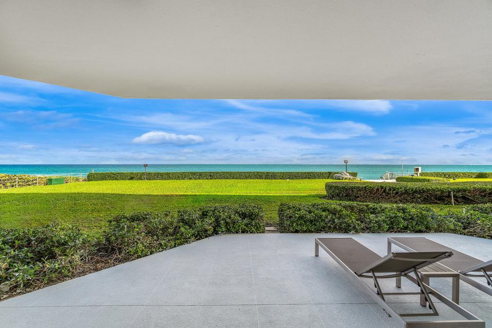 The terrace off the living room looks directly across the lawn to the ocean.