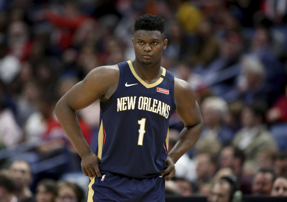 FILE - In this March 6, 2020, file photo, New Orleans Pelicans forward Zion Williamson walks onto the court during the second half of the team's NBA basketball game against the Miami Heat in New Orleans. The rookie sensation’s availability to play remained unclear as the season’s resumption in Lake Buena Vista, Florida, approached. He left the NBA’s so-called “bubble” setup on July 16 to attend to an unspecified family medical matter. A week later, the club had yet to provide an update on his possible return. (AP Photo/Rusty Costanza, File)