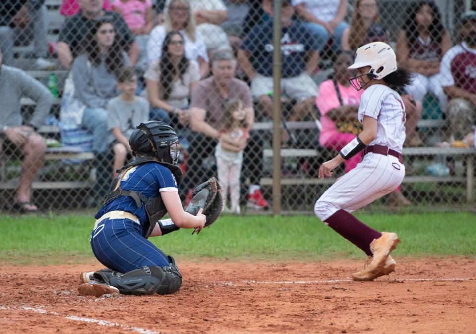 Catcher Sophie Mislevy (14) gets set to tag Ciara Steadman (7) out at the plate during the Gulf Breeze vs Navarre softball game at Navarre High School on Tuesday, April 26, 2022.