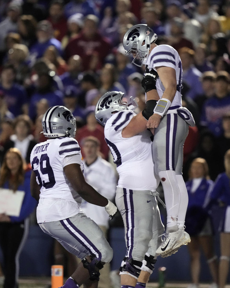 Kansas State quarterback Will Howard, right, celebrates with Kansas State offensive lineman Cooper Beebe, center, after scoring a touchdown during the second half of an NCAA college football game Saturday, Nov. 18, 2023, in Lawrence, Kan. (AP Photo/Charlie Riedel)