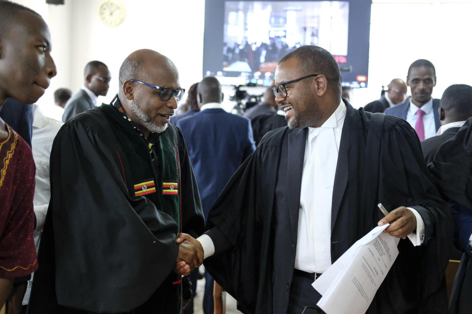Martin Mwambustya, right, director of civil litigation in the attorney general's office, shakes hand with Pastor Martin Ssempa at the Constitutional Court in Kampala, Uganda, Wednesday April 3, 2024, as the court gives its seal of approval on the anti-homosexuality law, declaring that the Anti Homosexuality Act of 2023 complies with the Constitution of Uganda. (AP Photo/Hajarah Nalwadda )