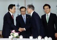 South Korean President Moon Jae-in, second from right, shakes hands with Hwang Kyo-ahn, the main opposition Liberty Korea Party chairman, during a meeting with ruling and opposition party leaders to talk about an ongoing South Korea-Japan trade conflict at the presidential Blue House in Seoul, South Korea, Thursday, July 18, 2019. (Bee Jae-man/Yonhap via AP)