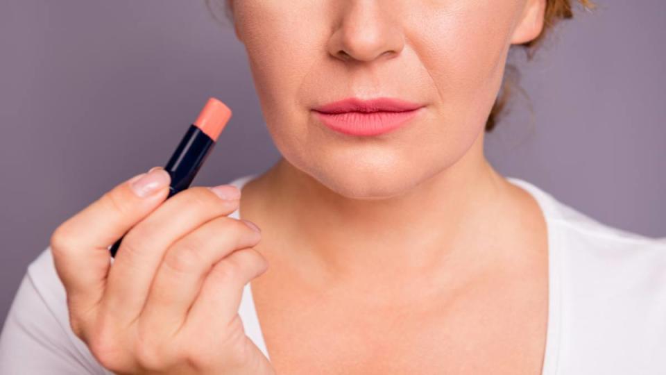 Uses for ice cubes: Cropped close up photo beautiful amazing mature she her lady hold new collection pomade applying putting great result lipgloss go romantic date wear white t-shirt isolated grey background.