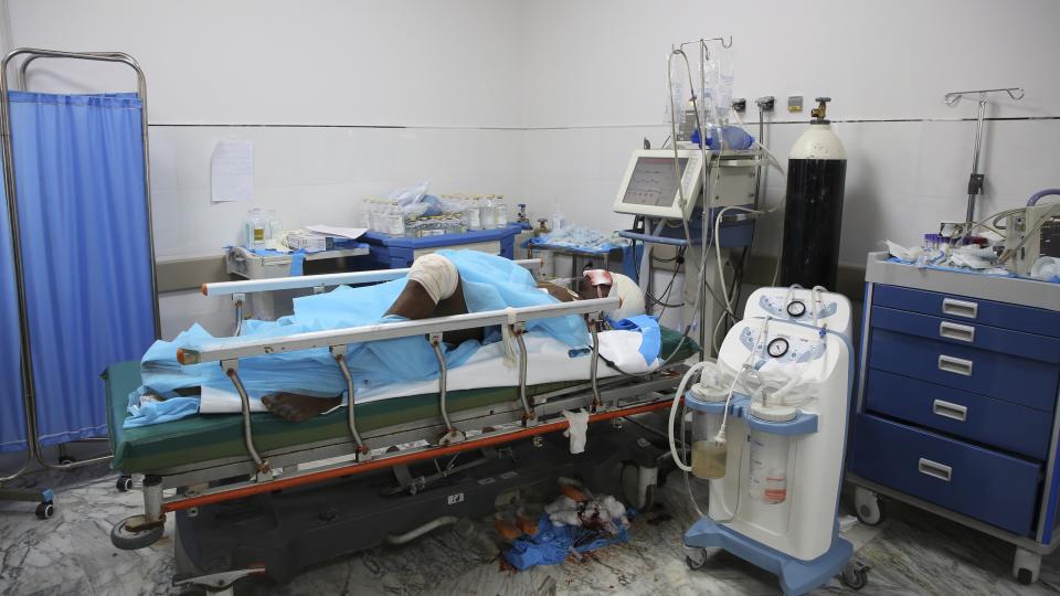 An injured migrant is treated inside a Tripoli, Libya, after an airstrike at a detention center in Tajoura, east of Tripoli, Wednesday, July 3, 2019. An airstrike hit the detention center for migrants early Wednesday, killing several. (AP Photo/Hazem Ahmed)