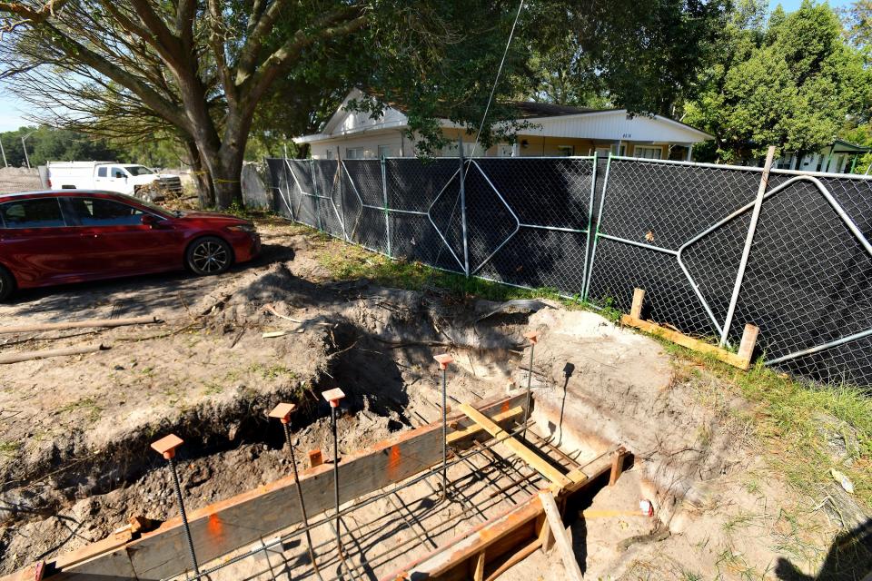 Construction fencing separates the footer forms from a nearby house in the Golfair Manor subdivision. The city is building a new two-story Medical Examiner's Office building off Interstate 95 between Golfair Boulevard and the subdivision.