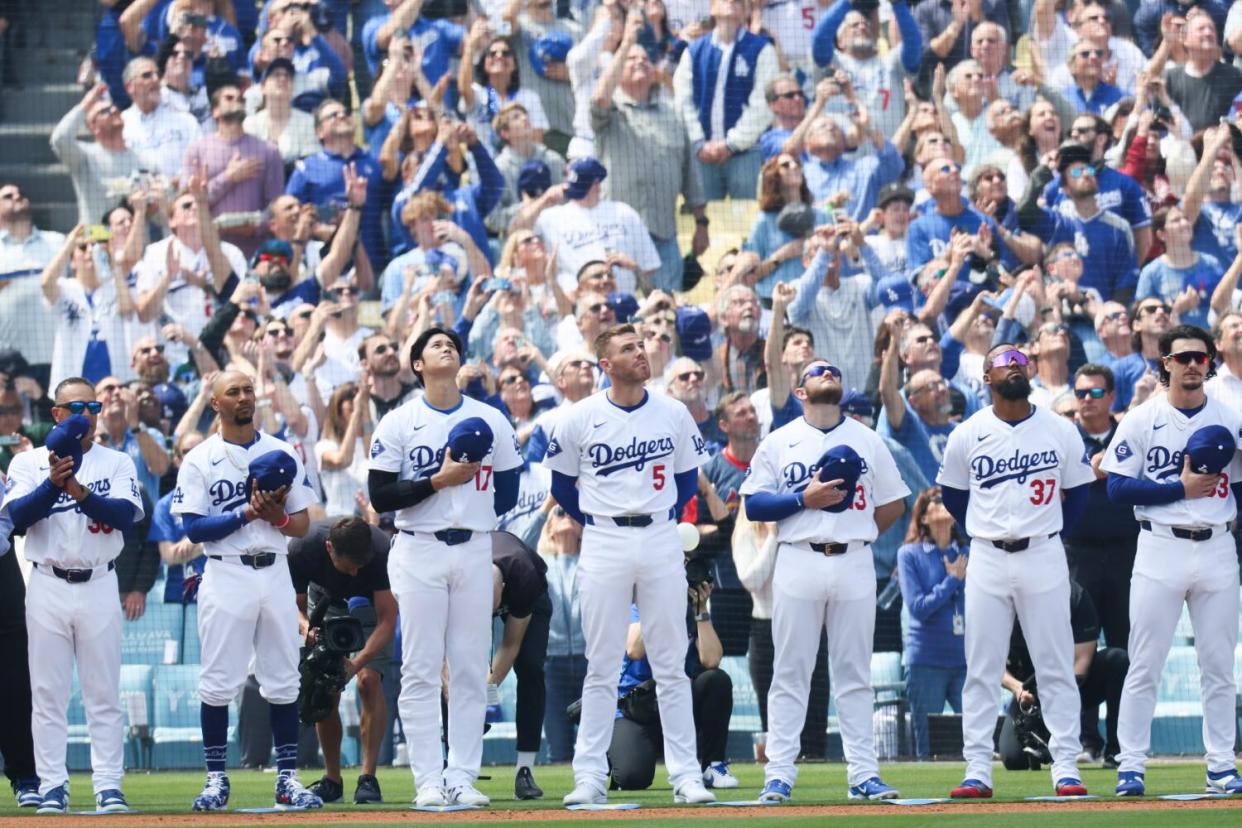 The Los Angeles Dodgers stand for the national anthem.