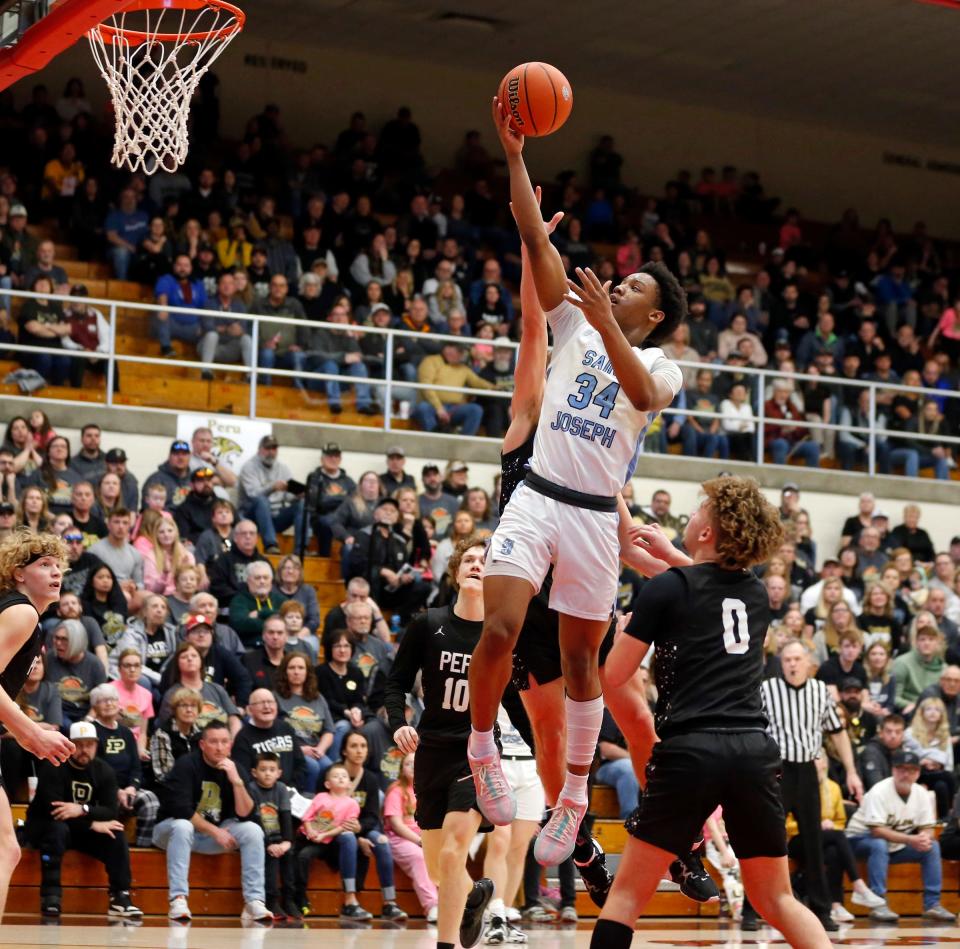 Saint Joseph freshman Elijah King (34) puts up a layup during an IHSAA Class 3A boys basketball semistate semifinal game against Peru Saturday, March 16, 2024, at Logansport High School.