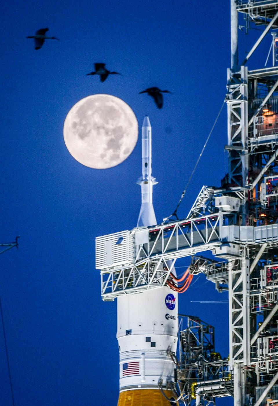 The first full moon in June called the Strawberry Moon sets over the Orion capsule atop NASA’s Space Launch System rocket at Kennedy Space Center, FL Wednesday, June 15, 2022.