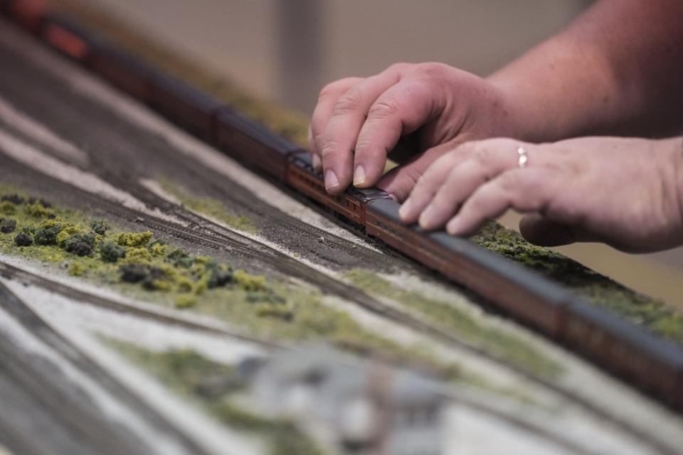 Paul Bender, a member of the Central Ohio N Trak group, adjusts a model train on a layout during the Great Train Show. It took the group almost five hours to assemble the layout before the show, Bender said, not including the months it took to assemble the wiring and displays.