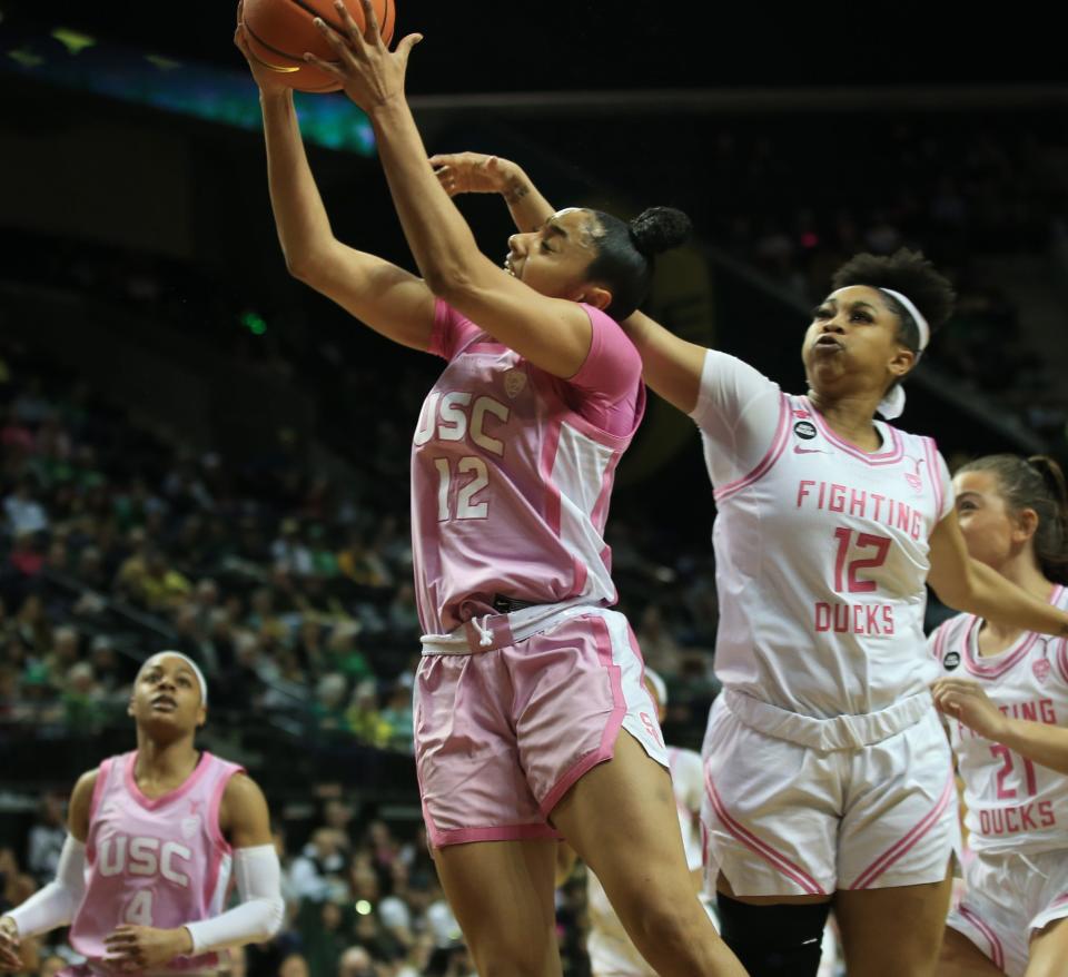 USC’s JuJu Watkins slides by Oregon’s Kennedi Williams on her way to the basket during the first half at Matthew Knight Arena in Eugene Friday, Feb. 16, 2024.