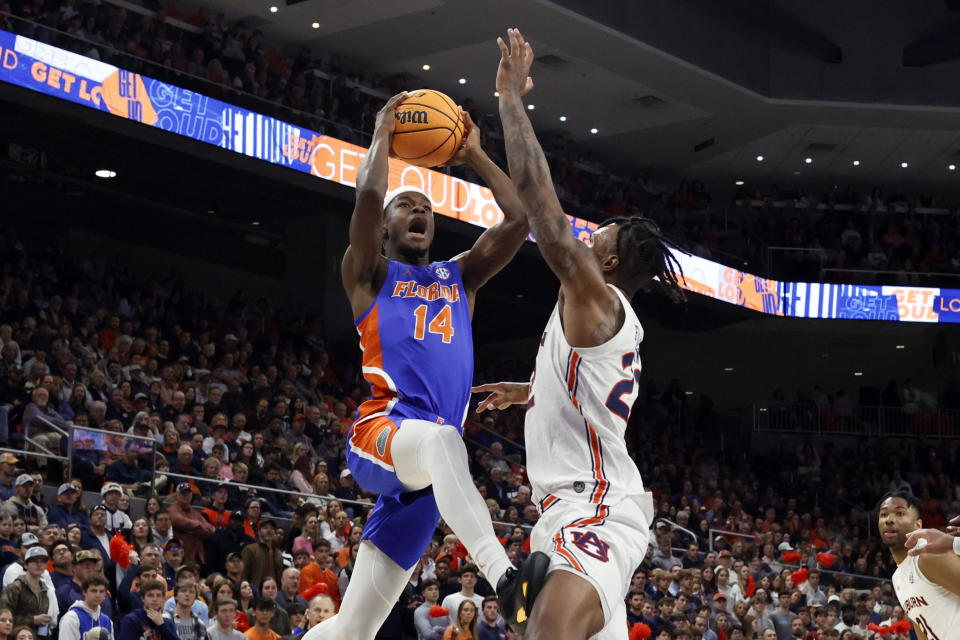 Florida guard Kowacie Reeves (14) goes up for a shot as Auburn guard Allen Flanigan (22) defends during the first half of an NCAA basketball game Wednesday, Dec. 28, 2022, in Auburn, Ala. (AP Photo/Butch Dill)