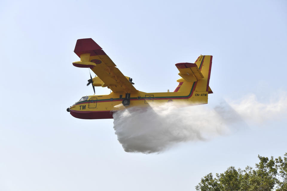 Fire fighting planes drop water to put out a forest blaze in Laarache, northern Morocco, Friday, July 15, 2022. Fires fanned by strong winds and extreme temperatures have spread across hundred of hectares in North Africa since Thursday evening. (AP Photo)