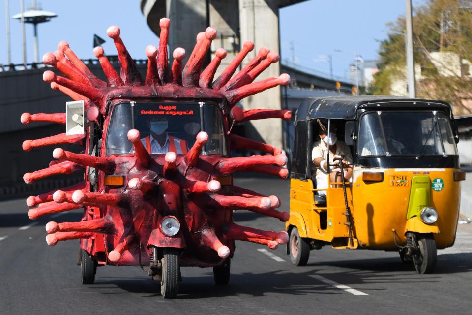 <p>A municipal health worker drives an auto-rickshaw decorated as a coronavirus model </p>AFP via Getty Images